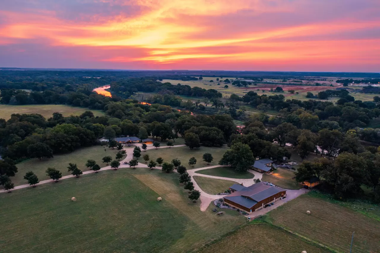 Beautiful sunsets provide a colorful backdrop to the property’s manicured grounds, with the sun’s red and orange hues reflected on the surface of the Brazos River. TexasLuxuryAuction.com. img#1