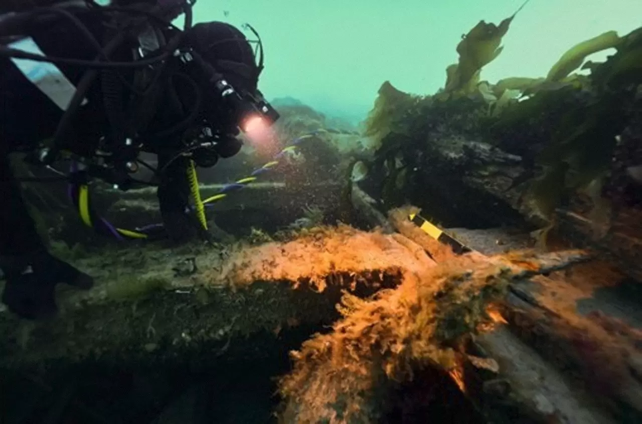 Parks Canada Underwater Archaeologist examines a belaying pin on the upper deck of HMS Erebus, September 2022. Credit: Marc-André Bernier, Parks Canada (CNW Group/Parks Canada) img#1