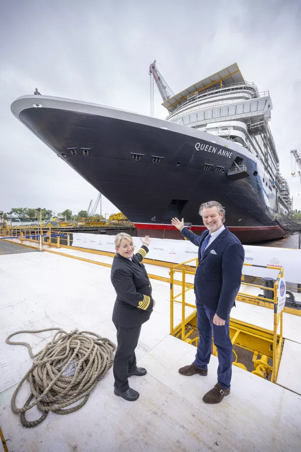 Captain Inger Klein Thorhauge and Sture Myrmell, Carnival UK President in front of Cunard’s newest ship, Queen Anne, at the Fincantieri Marghera shipyard in Venice, Italy. (Cunard) img#4