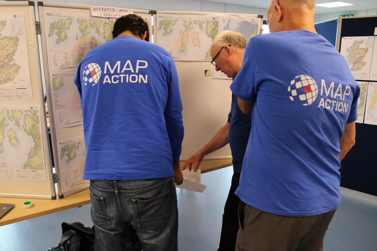 MapAction volunteers review details on a map on the 'map wall'. Photo: MapAction img#2
